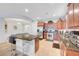 Bright kitchen featuring a central island with seating, wooden cabinetry, and modern appliances at 2613 Velodrome Ct, Henderson, NV 89044
