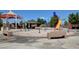 A well-maintained splash pad area with colorful play structures and seating beneath a shady canopy at 2613 Velodrome Ct, Henderson, NV 89044