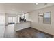 Open-concept kitchen with stainless appliances, white cabinets, gray countertops, and adjacent dining area with gray floors at 2728 Pavehawk Way, Las Vegas, NV 89156