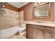 Bathroom with tile floors, wooden vanity, framed mirror, and shower over tub with tile surround at 2832 Cape Hope Way, Las Vegas, NV 89121