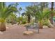 A tranquil courtyard space with a bench surrounded by desert landscaping and palm trees, perfect for relaxation at 2832 Cape Hope Way, Las Vegas, NV 89121