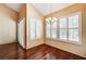 Well-lit dining room featuring a chandelier, plantation shutters, hardwood flooring, and high ceilings at 2832 Cape Hope Way, Las Vegas, NV 89121