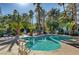 Community pool surrounded by palm trees, chaise lounges, and lush landscaping at 2832 Cape Hope Way, Las Vegas, NV 89121
