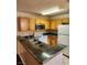 Well-lit kitchen featuring wood cabinetry, a microwave, and a peninsula countertop at 2974 Juniper Hills Blvd # 104, Las Vegas, NV 89142