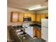 Well-lit kitchen featuring wood cabinetry, a microwave, and a peninsula countertop at 2974 Juniper Hills Blvd # 104, Las Vegas, NV 89142