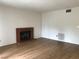 Living room with wood-look flooring, brick fireplace, and neutral paint at 3138 White Rose Way, Henderson, NV 89014