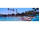 A beautiful beach view with palm trees, blue umbrellas, and calm water at 3150 Soft Breezes Dr # 1050, Las Vegas, NV 89128