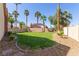 Back yard featuring green grass, small palm trees, and rock landscaping at 326 Fuente Dr, Henderson, NV 89014