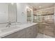 Beautiful bathroom featuring a double vanity with quartz countertops and tiled shower at 326 Fuente Dr, Henderson, NV 89014