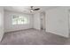 This bedroom features neutral carpet, a ceiling fan, and a bright window view at 326 Fuente Dr, Henderson, NV 89014