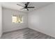 Bright bedroom featuring wood floors, neutral walls, ceiling fan, and a window with a view to the outdoors at 326 Fuente Dr, Henderson, NV 89014