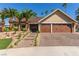 Beautiful single-story home boasts a three-car garage, brick driveway, and lush landscaping with mature palm trees at 326 Fuente Dr, Henderson, NV 89014