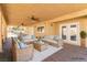 Covered patio with comfortable seating, ceiling fans, and serene backyard views at 326 Fuente Dr, Henderson, NV 89014