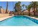 Inviting pool offering a refreshing escape surrounded by palm trees and lush landscaping at 326 Fuente Dr, Henderson, NV 89014