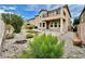 Home backyard with small trees, bushes, rocks, and artificial grass at 3624 Pelican Brief Ln, North Las Vegas, NV 89084