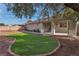 A beautifully landscaped backyard with synthetic grass and a covered patio, perfect for outdoor enjoyment at 3713 Nairobi Ln, North Las Vegas, NV 89032