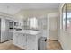 Modern white kitchen with stainless appliances, island and backyard access at 3713 Nairobi Ln, North Las Vegas, NV 89032