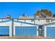 Exterior showing blue garages with white trim under a clear sky at 4078 Gold Coast Dr, Las Vegas, NV 89121