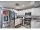 Image of kitchen with stainless appliances, granite, white cabinets, and large fridge at 4078 Gold Coast Dr, Las Vegas, NV 89121