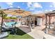 Spacious backyard with a pool, patio seating, and lush artificial grass at 4115 Ridgewood Ave, Las Vegas, NV 89120