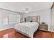 Bedroom featuring wood floors, dresser, queen bed, and backyard view at 4115 Ridgewood Ave, Las Vegas, NV 89120
