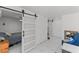 Modern bedroom boasts barn doors, light tile floors, and comfortable furnishings, creating a cozy atmosphere at 4115 Ridgewood Ave, Las Vegas, NV 89120