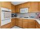 Cozy kitchen features wood cabinetry, white countertops, and appliances at 4115 Ridgewood Ave, Las Vegas, NV 89120