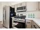 Updated kitchen features stainless steel range, microwave, refrigerator, and bright countertops at 4336 Fenton Ln, North Las Vegas, NV 89032