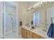 Bright bathroom with double sinks, vanity with storage, and a separate shower enclosed with glass at 437 Pinnacle Heights Ln, Las Vegas, NV 89144