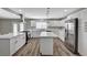 Renovated kitchen boasts white cabinetry, stainless steel appliances, and a marble countertop island at 4387 Sun Vista Dr, Las Vegas, NV 89104