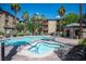 Community swimming pool and spa surrounded by lounge chairs and palm trees at 4400 S Jones Blvd # 2075, Las Vegas, NV 89103