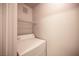 Compact laundry area with a white top-load washing machine and a wire shelf above at 4400 S Jones Blvd # 2075, Las Vegas, NV 89103
