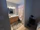Functional bathroom features a light vanity, a mirror and a patterned shower curtain at 4568 Little Finch Ln, Las Vegas, NV 89115