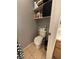Compact half-bathroom features a standard toilet and storage shelves to optimize space at 4568 Little Finch Ln, Las Vegas, NV 89115