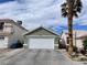 Charming one-story home featuring a two-car garage and lush landscaping with a palm tree at 4568 Little Finch Ln, Las Vegas, NV 89115