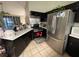 Functional kitchen with modern appliances, dark cabinets, and tile floors for easy maintenance at 4568 Little Finch Ln, Las Vegas, NV 89115
