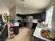 Well-lit kitchen with stainless steel appliances, dark cabinetry, and tile flooring at 4568 Little Finch Ln, Las Vegas, NV 89115