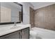 Bathroom with dark vanity, white sink, and combination shower and tub with tiled walls at 4644 Canna Dr, Las Vegas, NV 89122