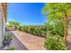 Serene backyard featuring a brick patio, garden beds, and a covered hot tub with mature landscaping at 4893 E Cedar Creek Way, Pahrump, NV 89061
