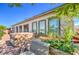 Landscaped backyard featuring a brick patio, lush garden beds, and a covered hot tub at 4893 E Cedar Creek Way, Pahrump, NV 89061