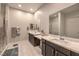 Modern bathroom with double vanity, large mirrors, neutral color scheme, and a glass-enclosed shower at 4893 E Cedar Creek Way, Pahrump, NV 89061