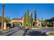 Grand community entrance with an archway, landscaping, and flags at 5067 Pensier St, Las Vegas, NV 89135