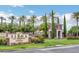 Elegant community entrance with a stone sign, flowers, and manicured landscaping at 5067 Pensier St, Las Vegas, NV 89135