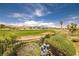 Scenic view of the lush golf course with palm trees under a blue sky at 5067 Pensier St, Las Vegas, NV 89135