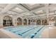 Stunning indoor swimming pool with arched windows, intricate wall art, and elegant lighting at 5067 Pensier St, Las Vegas, NV 89135