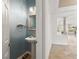Stylish powder room featuring a pedestal sink, decorative mirror, and adjacent view to the golf course at 5067 Pensier St, Las Vegas, NV 89135