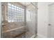 Modern walk-in shower featuring glass blocks, a built-in bench, and stylish fixtures for a luxurious spa-like experience at 5067 Pensier St, Las Vegas, NV 89135