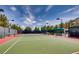 Well-maintained tennis court with a shaded viewing area and lush greenery, perfect for outdoor recreation at 5067 Pensier St, Las Vegas, NV 89135