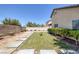 View of backyard with concrete pavers, small lawn and desert landscaping for low maintenance at 5213 Giallo Vista Ct, North Las Vegas, NV 89031