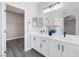 Bathroom featuring double sinks with quartz countertops, black hardware, and wood-look flooring at 5213 Giallo Vista Ct, North Las Vegas, NV 89031